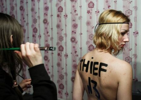 An activist of Ukrainian group Femen writes a text on the back of her fellow member in a flat as they prepare for an action at the Sunday's presidential election in Moscow, March 3, 2012. Reuters/Denis Sinyakov