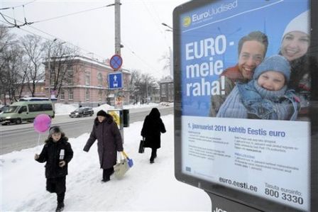 Les gens passent devant une affiche qui dit "L'Euro est notre argent" à Tallinn, en Estonie, le lundi 27 décembre 2010.