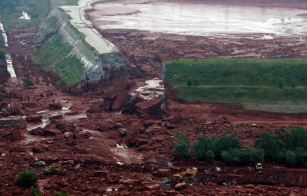 Tuesday, Oct. 5, 2010 shows the ruptured wall of a red sludge reservoir of the Ajkai Timfoldgyar plant in Kolontar, 160 km (100 mi) southwest of Budapest, Hungary. Note the excavators at bottom to give a sense of scale. (AP Photos/MTI, Gyoergy Varga)